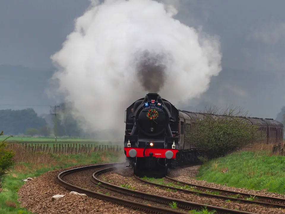 A vintage steam train travelling through the English countryside